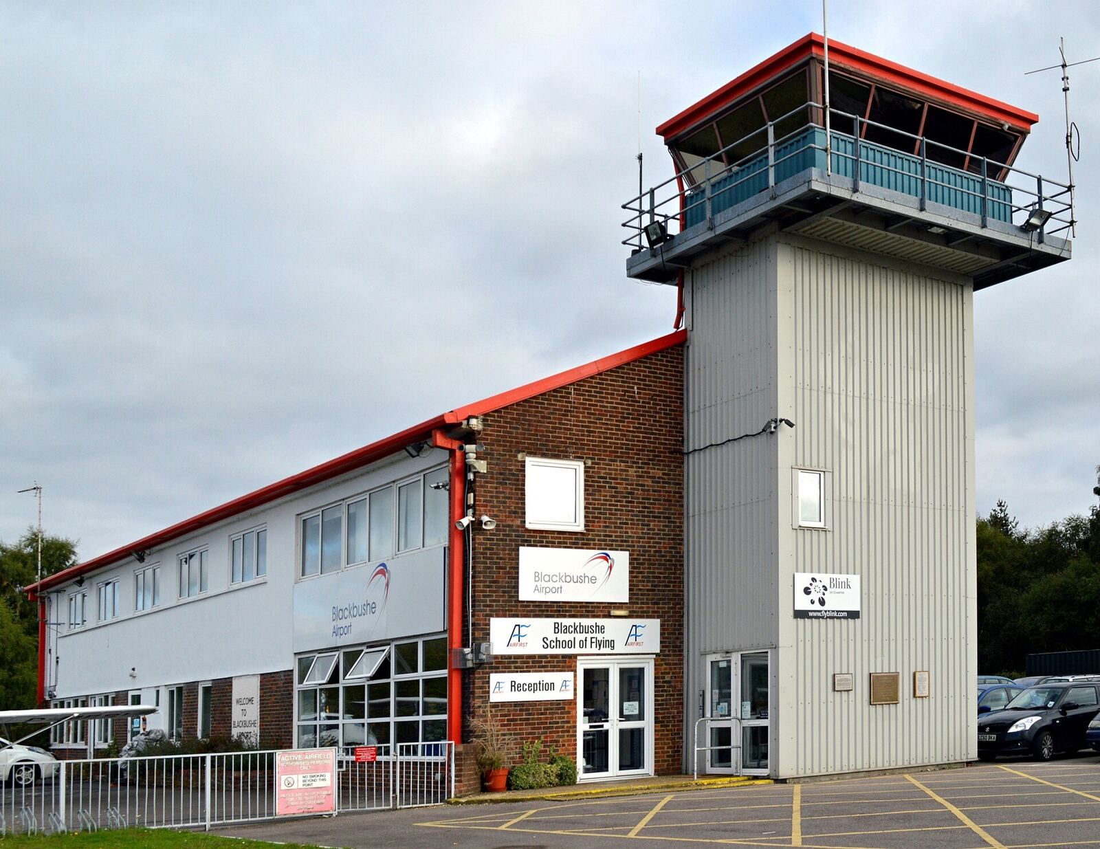 The control tower at Blackbushe Airport, a white tower with a red-framed cab above a brick building
